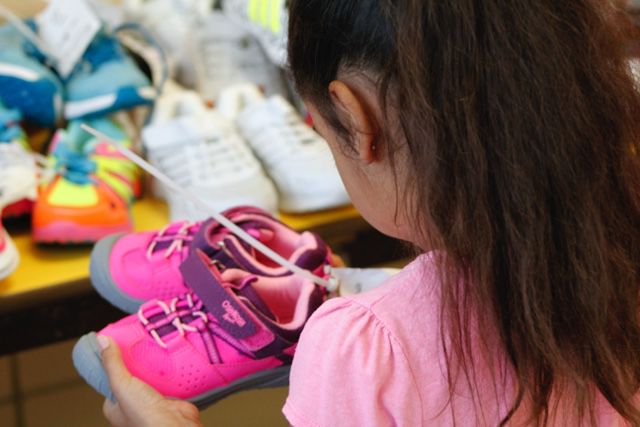 A young girl checking out her new sneakers at LifeWiseStl back-to-school event.JPG